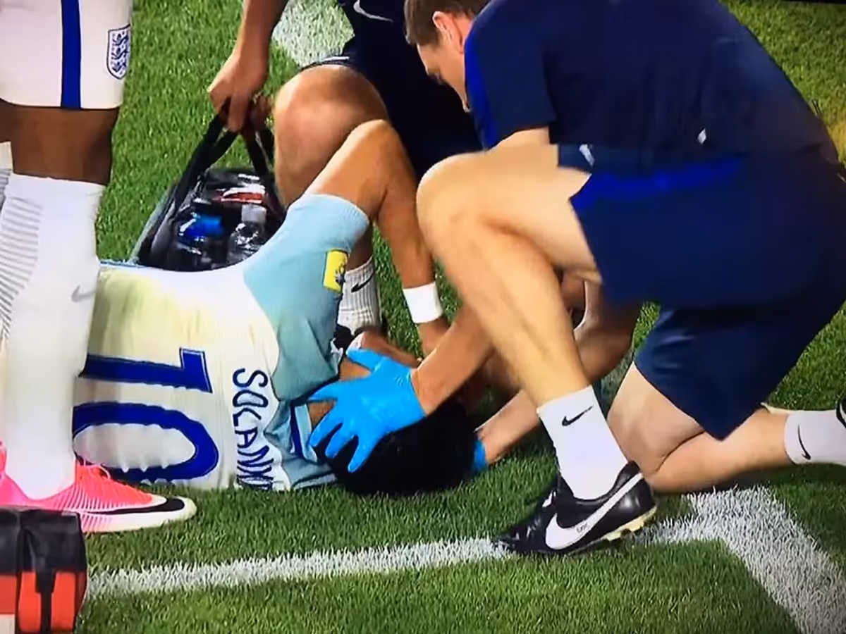 Footballer receiving on-pitch treatment for a muscle injury